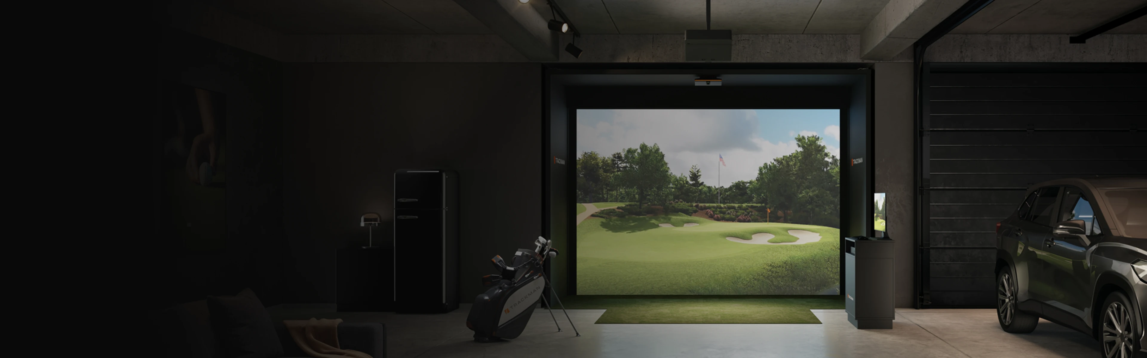 Indoor golf simulator setup in a garage with a screen showing a golf course, a bag of clubs, and a parked car nearby.